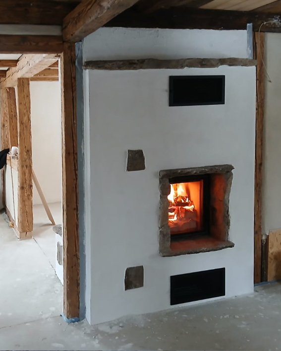 Naturstein Kamin zwischen Fachwerkbalken - heizen in mehreren Räumen